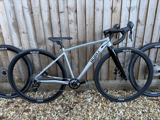 Grey road bike alongside a spare HUP CC wheelset